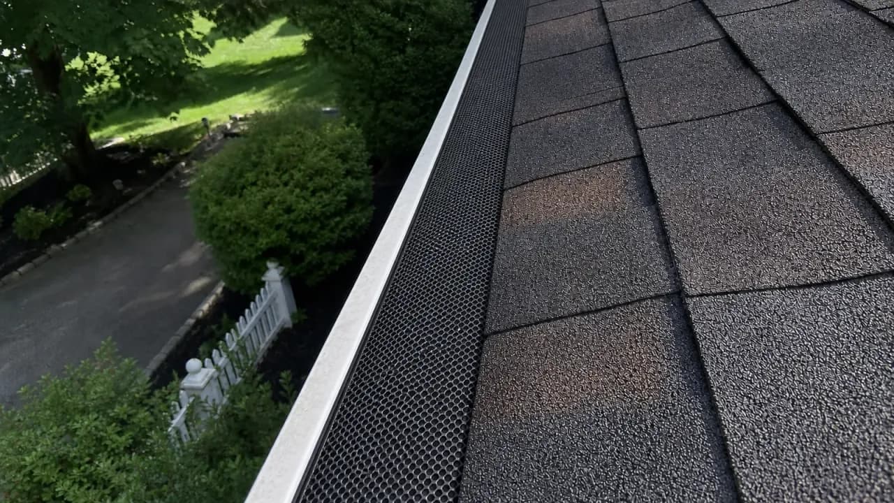 Representative after image of a clean gutter with a black mesh guard installed